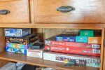 Board games located off the living room in the kitchen island cupboards.